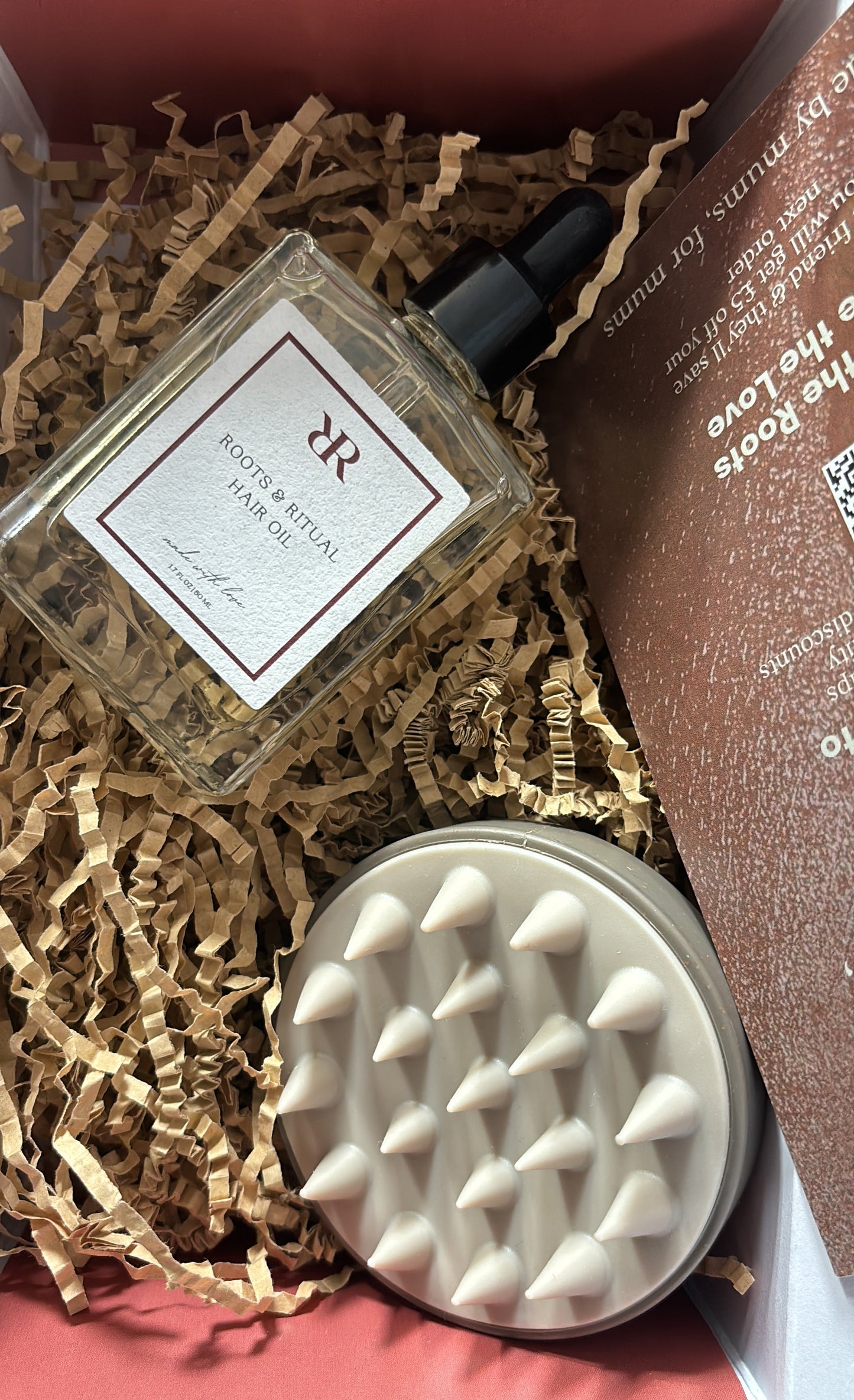 Postpartum Hair growth oil, scalp massager gift set on crinkled texture background